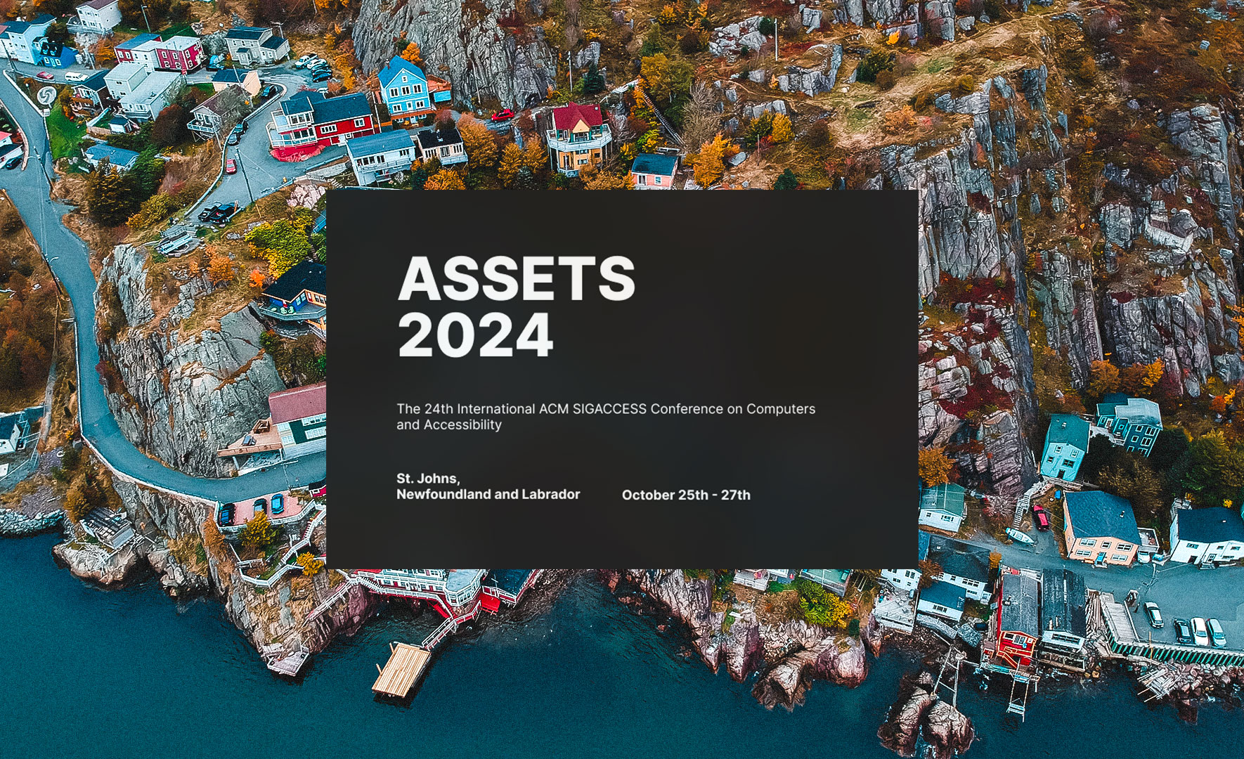 A screenshot of the ASSETS 2024 website. On a background of St. John's Newfoundland, there is a semi-translucent black box which says in all capital letters ASSETS 2024.